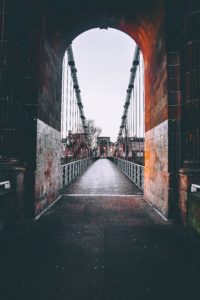 View through a red brick tunnel across a Glasgow bridge