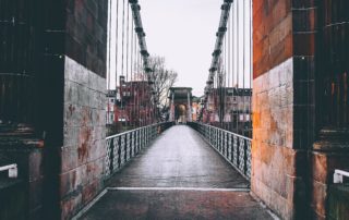 View through a red brick tunnel across a Glasgow bridge