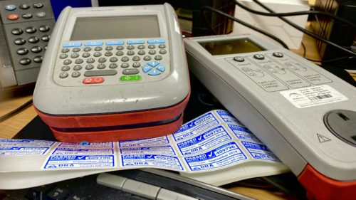 Two PAT testers with PAT testing labels Seaward Apollo 600 PAT tester and a Seaward Primetest 100 PAT testing machine with blue and white PAT labels