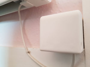 An closed socket cover over a timer switch for a fan system on a pink wall
